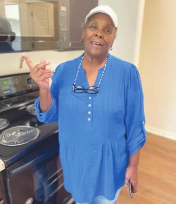 Doris Jones admires her new kitchen while holding her keys for the first time Aug. 11 in Wallis. HANS LAMMEMAN