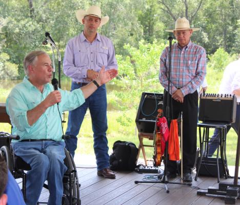 Gov. Greg Abbott shared the stage with County Judge Tim Lapham and local musician Robert Herridge during his speech at the Grand Old Picnic, hosted by the Austin County Republican Party Saturday, Aug. 6, in New Ulm. HANS LAMMEMAN