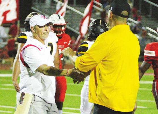 Head Coaches Grady Rowe and Shane Mobley meet at midfield following the Battle of Mill Creek at the Pasture of Pain Oct. 15, 2021. Bellville and Sealy will once again compete in the same district following Feb. 3’s biennial realignment of the UIL. COLE McNANNA