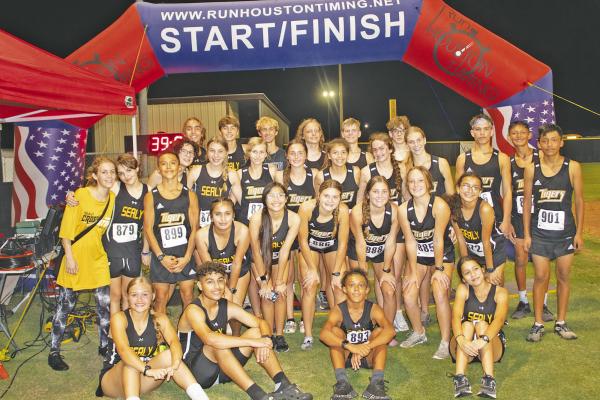 JASON MANAGO-GRAVES The Sealy High School Tigers boys and girls cross-country team pose for a photo at the finish line following their races at the Frio Friday Night Lights meet.