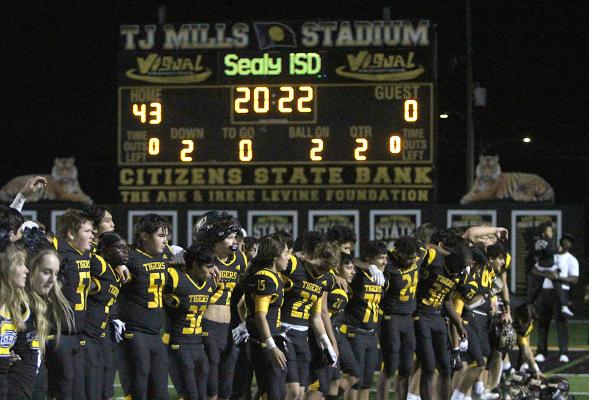 The Sealy Tigers line up for the playing of their school song after the 43-0 win over La Marque in the regular-season finale Friday night on Mark A. Chapman Field at T.J. Mills Stadium. COLE McNANNA