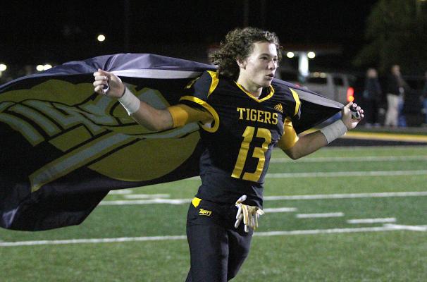 Sealy senior Gage Grigar celebrates with the victory flag during the Senior Walk that followed the Tigers’ 43-0 win over La Marque in the final game of the regular season Friday night at T.J. Mills Stadium. COLE McNANNA