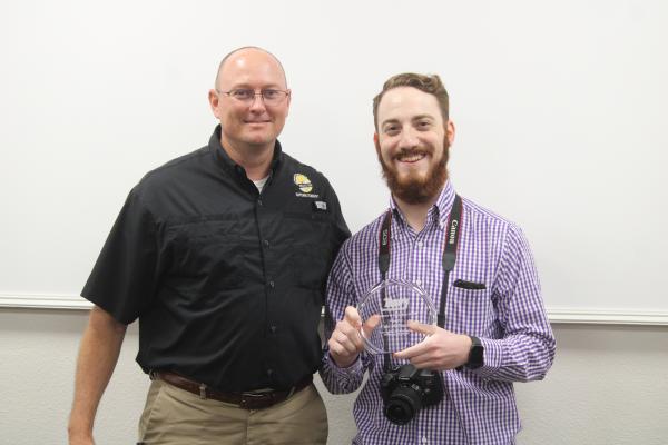 Sealy ISD Superintendent Bryan Hallmark presented Sealy News Managing Editor Cole McNanna with an excellence in journalism award during the March 30 regular meeting at the Administration Building. TRENTON WHITING/COLORADO COUNTY CITIZEN