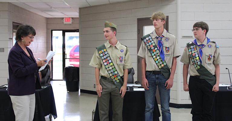 Sealy Mayor Carolyn Bilski read a note of recognition for a trio of Sealy scouts who recently achieved Eagle rank ahead of the Aug. 2 regular meeting at the W. E. Hill Community Center. From the left are Ike Konvicka, Cameron Eschenburg and Zander Crawley. KAREN LOPEZ
