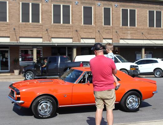 Jacob Huddleston and his son Grady admire one of the cars on display at the Father’s Day Car Social in downtown Sealy June 19. COLE McNANNA