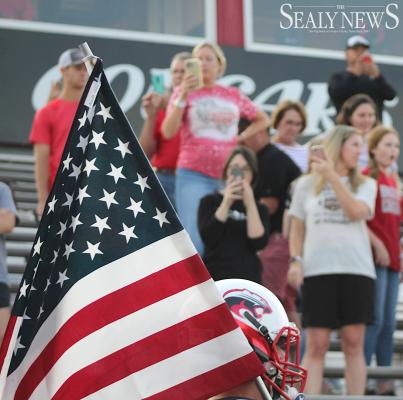 Brazos Cougar football players carried American flags with them through the stands before taking the field for last Friday’s game against Burton on Stars and Stripes night at Cougar Stadium in Wallis. COLE McNANNA