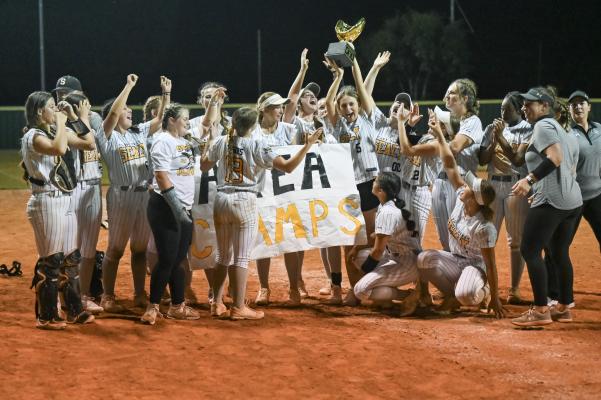 Sealy’s softball squad lifts up the area championship after sweeping state-ranked Cuero last Friday in Halletsville. Right: Sealy celebrates during its game two victory over Cuero last Friday in Halletsville. COURTESY PHOTOS