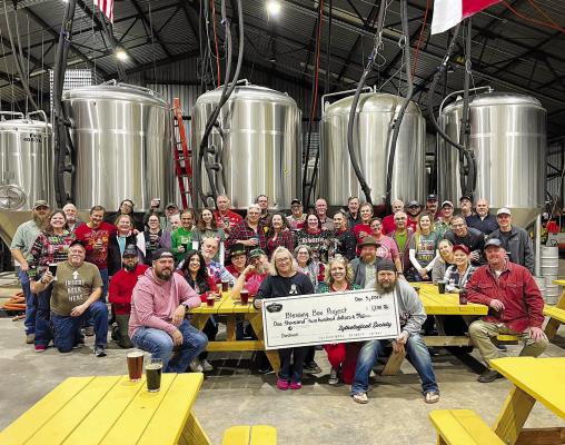 Members of the Zythological Society of North America presenting a check to Dawn Compton in the Brew House at Brazos Valley Brewing during the annual Zythmas party on Dec. 5.