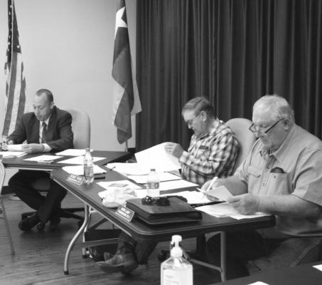 Tim Lapham, Robert “Bobby” Rinn and Mark Lamp scanned over documents during Monday’s meeting Sept. 27, at the Austin County Courthouse. HANS LAMMEMAN
